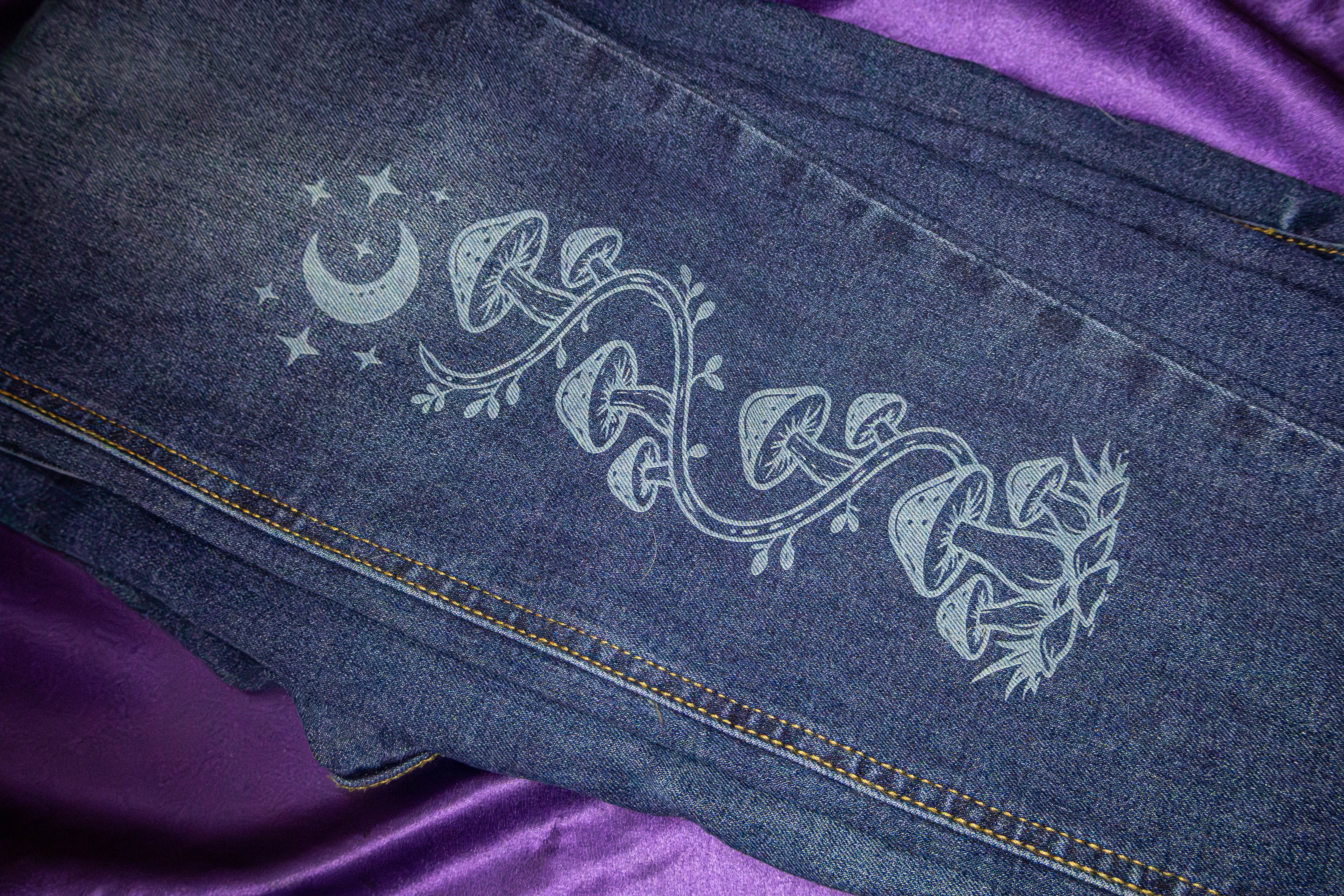 Laser engraved denim jeans with celestial mushroom design by Neurospice Design Shop